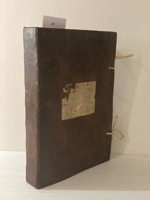 un livre brun posé sur une table blanche