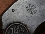 a close up of a gun on a table with a badge on it