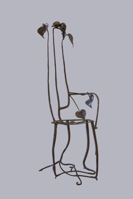 une chaise en métal décorée d'oiseaux, avec un oiseau sur le dossier