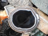 a picture of a black and white agate sitting on top of a pile of rocks