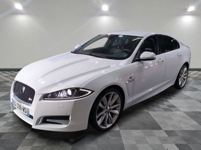 La Jaguar blanche est garée dans une grande pièce au sol carrelé en damier.
