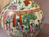 a vase with a painting on it sitting on a table