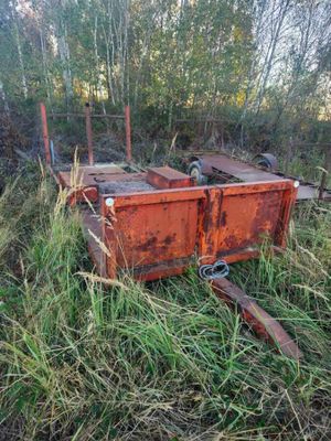 a rusted out dumpster sitting in the middle of a field
