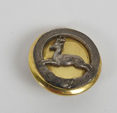 an image of a gold and silver broochle with a deer on it