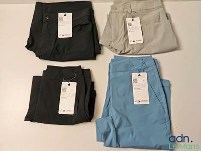 trois paires de pantalons pour homme sur lesquelles est encore accrochée l'étiquette de prix