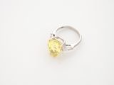 a yellow sapphire and diamond ring on a white surface