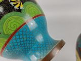 two vases with designs on them sitting next to each other