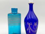 pair of blue glass bottles with gold trims and a blue glass bottle with a gold trim