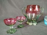 three different colored glass vases and two empty wine glasses