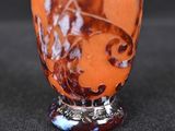 a picture of an orange and white vase on a black surface