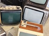 several old televisions are stacked on top of each other on the floor