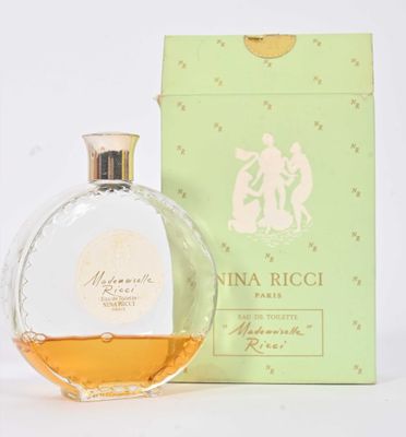 l'image d'un flacon de parfum posé à côté d'une boîte