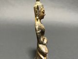 a small bronze statue of a woman holding a vase