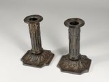 a pair of silver candlesticks on a white background