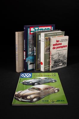plusieurs livres posés sur une table noire, avec une Coccinelle VW et une Coccinelle VW