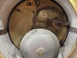 a white and gold clock sitting in the middle of a white wall