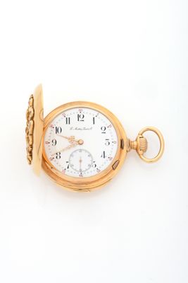 a gold pocket watch with roman numerals on it