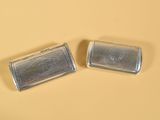 deux petits objets argentés posés sur une surface jaune