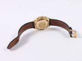 an image of a gold watch with a brown leather strap
