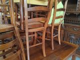 many wooden chairs and a table in a room