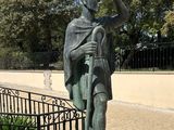 a statue of a man that is standing in front of a fence
