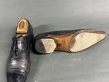 pair of men ' s leather shoes on a grey surface