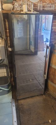 un miroir posé par terre à côté d'un tonneau en bois