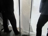 two people standing next to a table with a bag on it