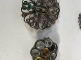 many different types of brooches displayed on a table