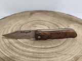 a knife that is sitting on top of a piece of wood