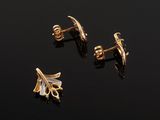 a pair of gold and diamond earrings on a black surface