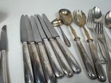a lot of silver spoons and forks on the table
