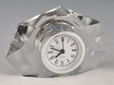 a glass clock with roman numerals on the face