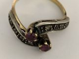 a close up of a gold ring with purple stones on a white surface