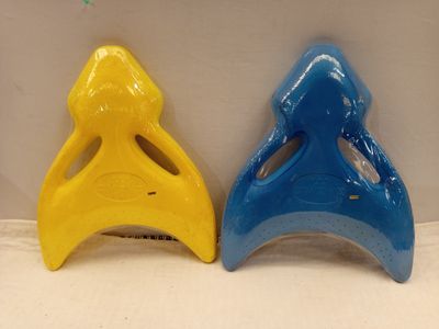 des peignes en plastique jaunes et bleus posés côte à côte sur une surface blanche