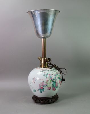 a white vase that has a metal bell on it