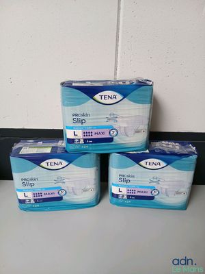 trois boîtes de chaussons Tena posées sur un comptoir