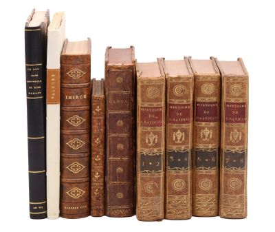 plusieurs vieux livres sont alignés sur une surface blanche