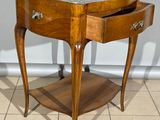 une petite table en bois avec un plateau en marbre, posée sur un sol carrelé