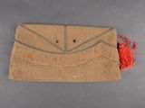 an image of a brown purse with a red tassel on it