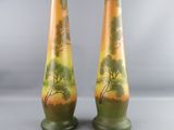 two vases with trees painted on them are sitting on a table