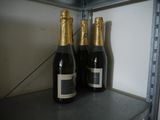 two bottles of champagne are sitting on a shelf in a refrigerator