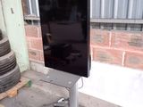 un téléviseur à écran plat posé sur un meuble devant un immeuble