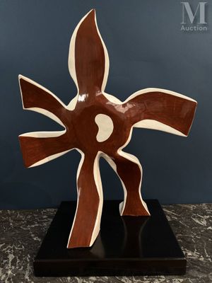sculpture abstraite marron et blanche posée sur un socle noir, elle-même posée sur une table