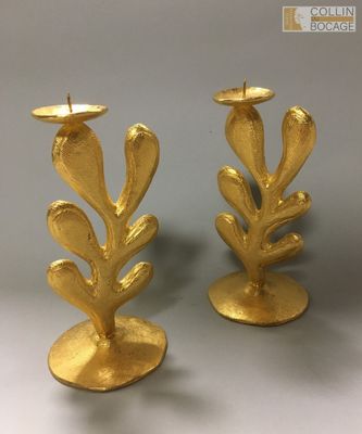 une paire de bougeoirs en feuille d'or sur fond blanc