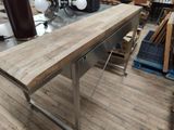 a wooden table with a metal base in a room