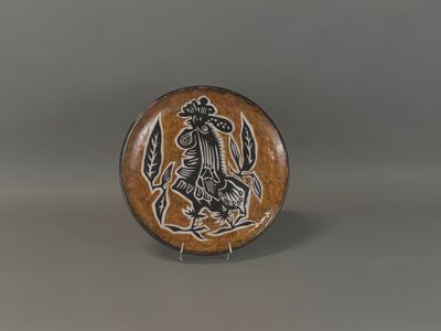 une image représentant une assiette marron et noire sur laquelle figure un oiseau