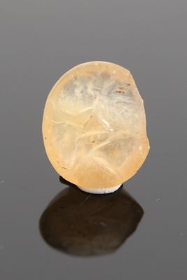 an image of a piece of yellow jade sitting on top of a black surface