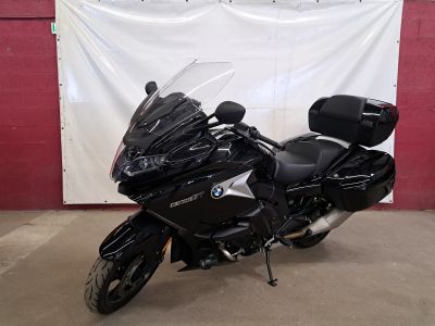 a black motorcycle parked in front of a red wall