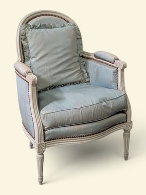 une photo d'une chaise bleue et blanche avec un coussin
